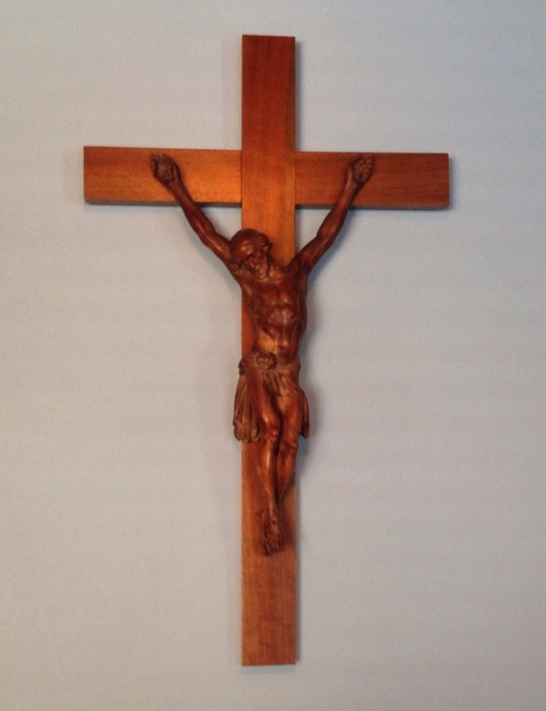 CRUCIFIX IN THE DINING ROOM AT  FREMONT A most precious gift to us from our St. Louis Community as three of the sister left there to come to Minneapolis, is this wood crucifix. It was probably carved by a prisoner in jail where our monastary chaplain was also a chaplain, so somehow this crucifix was in the sacristy for many years. What happened to the prisoner that he did not finish the work? There is no insignia and no crown of thorns. On the back is written a prayer by St. Francis de Sales and signed by of the members of the community at the time. 